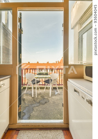 Front view of old brick buildings and cars with bicycles from small balcony with railings 93604045