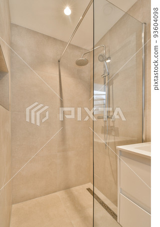Sinks with mirrors and shower box with glass door in modern bathroom with white tiled walls 93604098