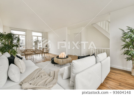 Shabby wooden table with chairs and vase located near comfortable couch against light walls with decorations and TV in modern apartment Shabby wooden table with chairs and vase located near comfortable couch against light walls with decorations and TV in modern apartment 93604148