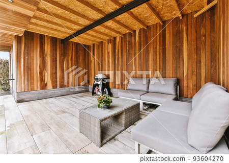 Neat paved patio with sitting area and small garden near wooden fence Neat paved patio with sitting area and small garden near wooden fence 93604270