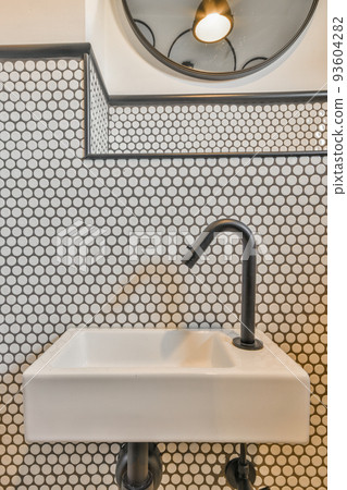 Sink with tap and liquid soap hanging on tiled wall under mirror in contemporary restroom at home Sink with tap and liquid soap hanging on tiled wall under mirror in contemporary restroom at home 93604282