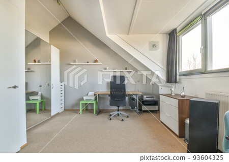 Comfortable chair placed near desk with computer monitors and whiteboard in light workplace in modern apartment Comfortable chair placed near desk with computer monitors and whiteboard in light workplace in modern apartment 93604325
