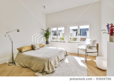 Home interior design of bedroom with bed and wooden wardrobe placed in corner near window in modern apartment 93604766