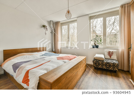 Home interior design of bedroom with bed and wooden wardrobe placed in corner near window in modern apartment Home interior design of bedroom with bed and wooden wardrobe placed in corner near window in modern apartment 93604945