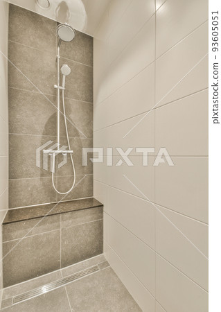 Glass partition between shower tap and wall hung toilet in modern restroom at home Glass partition between shower tap and wall hung toilet in modern restroom at home 93605051