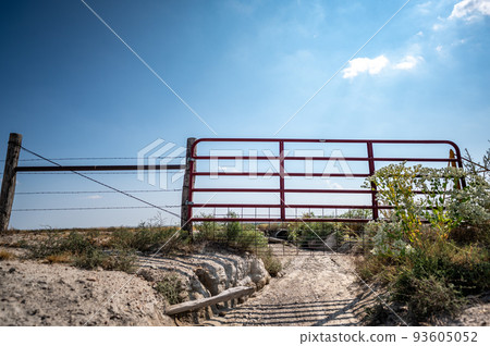 Water gap under a livestock fence where animals can go under a washed out section Water gap under a livestock fence where animals can go under a washed out section 93605052
