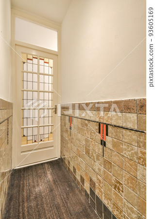 Interior of modern flat in minimal style with narrow empty corridor illuminated by lamps Interior of modern flat in minimal style with narrow empty corridor illuminated by lamps 93605169