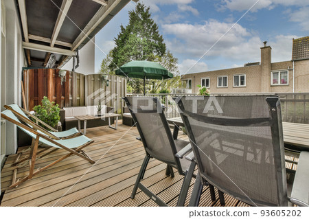 Narrow brick balcony with metal railings, wooden chair and door Narrow brick balcony with metal railings, wooden chair and door 93605202