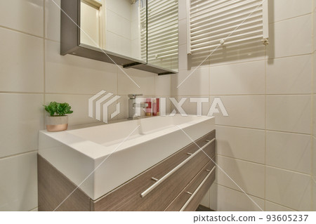 Sink with tap and liquid soap hanging on tiled wall under mirror in contemporary restroom at home Sink with tap and liquid soap hanging on tiled wall under mirror in contemporary restroom at home 93605237