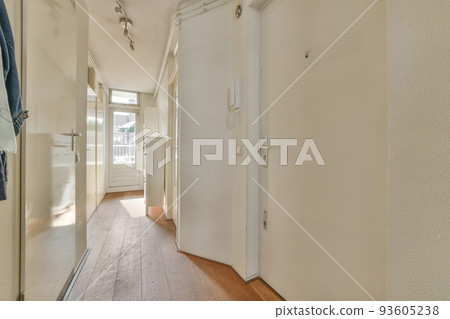 Light narrow hallway with many doors in white walls and glowing lamp over lumber floor Light narrow hallway with many doors in white walls and glowing lamp over lumber floor 93605238