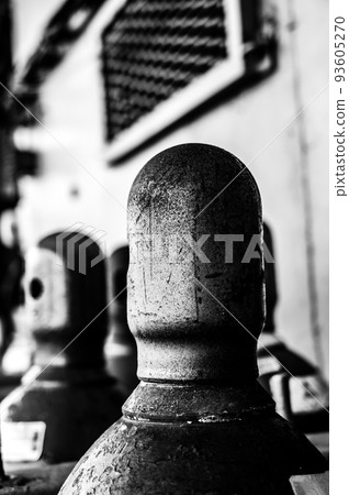 Compressed gas cylinders being stored vertically secured by a metal chain and a metal cap. 93605270