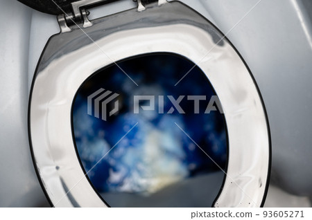 Inside a portable toilet with blue deodorizing disinfectant liquid. 93605271