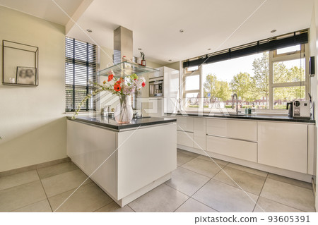 Spacious minimalist style dining room with table and chairs in modern apartment with white walls and wooden floor Spacious minimalist style dining room with table and chairs in modern apartment with white walls and wooden floor 93605391