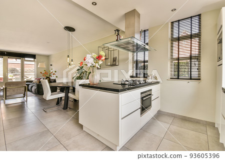 Spacious minimalist style dining room with table and chairs in modern apartment with white walls and wooden floor Spacious minimalist style dining room with table and chairs in modern apartment with white walls and wooden floor 93605396