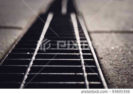 Grate over a stormwater trench in a concrete slab. Grate over a stormwater trench in a concrete slab. 93605398