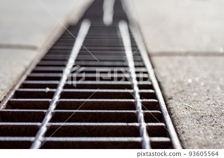 Grate over a stormwater trench in a concrete slab. Grate over a stormwater trench in a concrete slab. 93605564