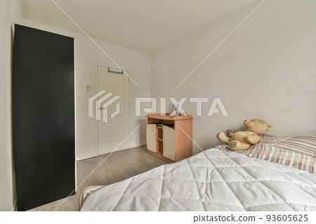Comfortable bed covered with checkered blanket and located in light bedroom of modern apartment Comfortable bed covered with checkered blanket and located in light bedroom of modern apartment 93605625