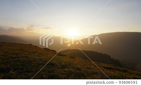 Sunset sun over yellow-green hills. Small clouds Sunset sun over yellow-green hills. Small clouds 93606591