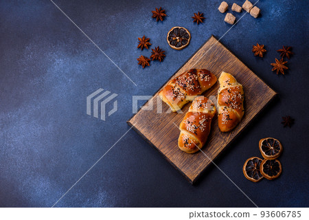Delicious homemade pastries with apricot jam sprinkled with sesame seeds Delicious homemade pastries with apricot jam sprinkled with sesame seeds 93606785
