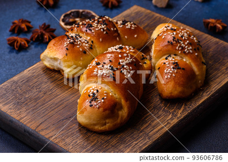 Delicious homemade pastries with apricot jam sprinkled with sesame seeds Delicious homemade pastries with apricot jam sprinkled with sesame seeds 93606786