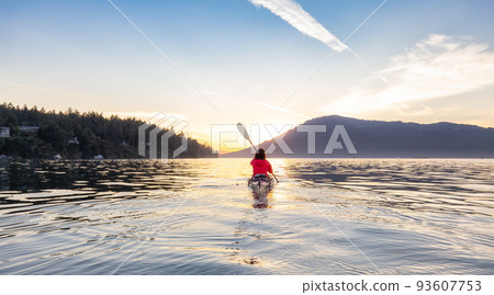 Adventurous Woman on Sea Kayak paddling in the Pacific Ocean. Sunny Summer Sunset Adventurous Woman on Sea Kayak paddling in the Pacific Ocean. Sunny Summer Sunset 93607753