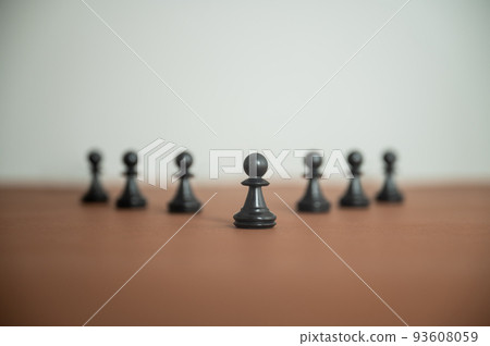 Chess pawn figures placed in a pyramid shaped line on brown surface Chess pawn figures placed in a pyramid shaped line on brown surface 93608059