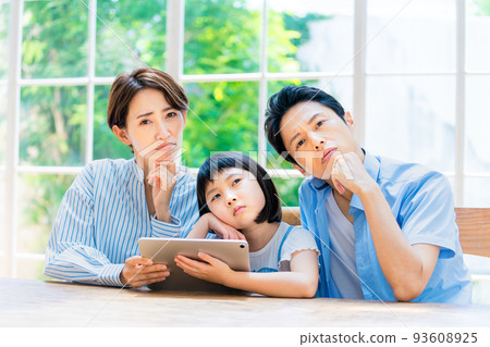 A family thinking while watching a tablet 93608925