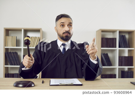 Portrait of stern judge knocking on judge's gavel passes sentence and declares case closed. 93608964