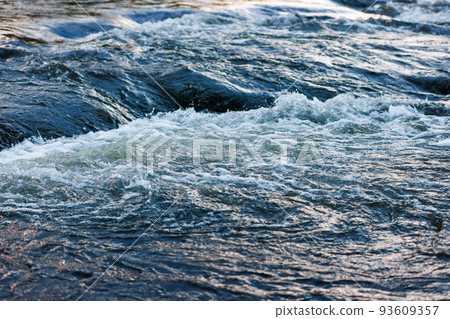 flowing water of a summer river with a small rapid waterfall at evening light flowing water of a summer river with a small rapid waterfall at evening light 93609357