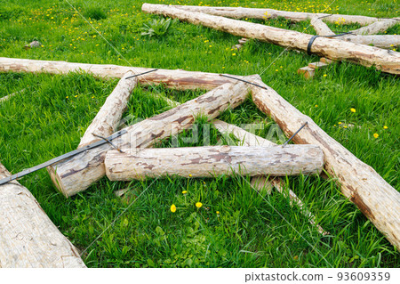 forged steel stripe connection of wooden log beams for roof support girder framework laid on green grass at summer day 93609359