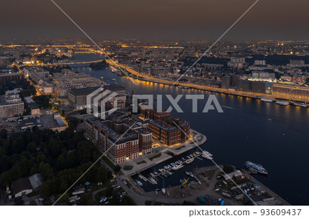 Aerial view of a picturesque sunset over housing on embankment of Neva river in St. Petersburg, the sights on background, illuminated highway Aerial view of a picturesque sunset over housing on embankment of Neva river in St. Petersburg, the sights on background, illuminated highway 93609437