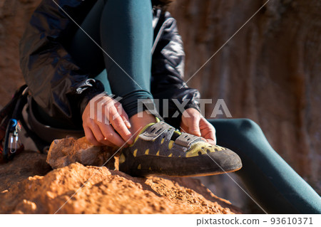 Girl is wearing climbing shoes, closeup view. Girl is wearing climbing shoes, closeup view. 93610371