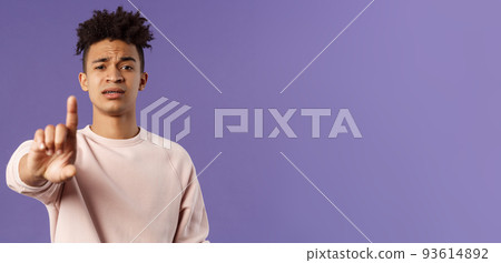 Close-up portrait of serious-looking hispanic man trying to prevent something bad, steping in for person being bullied, shaking index finger to scold wrong behavrious, forbid and prohibit something 93614892