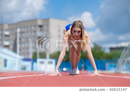 Female runner in the stadium is ready to race. 93615147