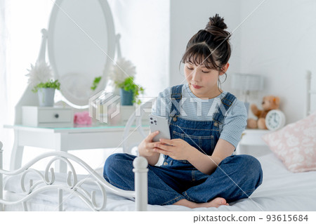 高中女生盤腿坐在床上,操作智能手機 高中女生盤腿坐在床上,操作智能手機 93615684