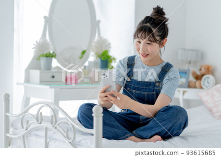 高中女生盤腿坐在床上,操作智能手機 高中女生盤腿坐在床上,操作智能手機 93615685