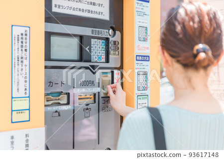 A woman who puts money in a coin parking lot 93617148