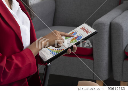 Bussineswoman working on annual report showing on electronic tablet. 93619383