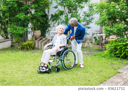 Husband pushing wife's wheelchair Senior family 93621732