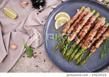 Healthy food - Asparagus wrapped with bacon and spices on a plate Healthy food - Asparagus wrapped with bacon and spices on a plate 93629328