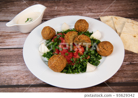 Vegetarian dish, falafel balls from spiced chickpeas with chopped parsley, fresh onions and tomato 93629342
