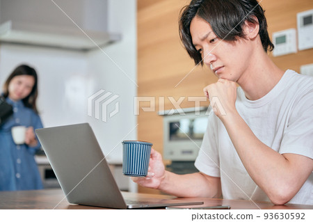 一個年輕人在遠程辦公時一邊喝咖啡一邊思考 93630592