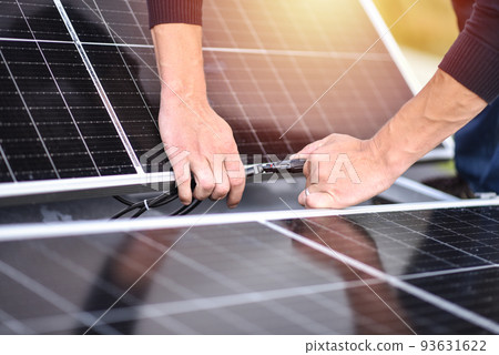 Connecting solar panels to each other. Rooftop solar power system mount, work. Green energy Connecting solar panels to each other. Rooftop solar power system mount, work. Green energy 93631622