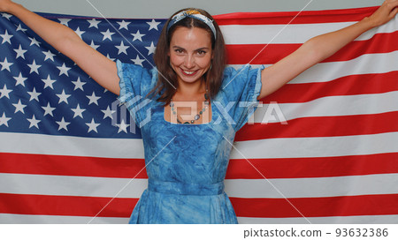 Lovely young woman waving and wrapping in American USA flag, celebrating, human rights and freedoms Lovely young woman waving and wrapping in American USA flag, celebrating, human rights and freedoms 93632386