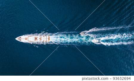 An aerial view of the yacht on the blue sea. Transparent clear water in the sea. An aerial view of the yacht on the blue sea. Transparent clear water in the sea. 93632694
