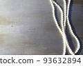 Pearl beads on a gray wooden background close-up. 93632894