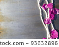 Pearl beads and rose petals on a gray wooden background close-up. 93632896