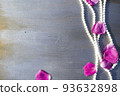 Pearl beads and rose petals on a gray wooden background close-up. 93632898