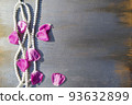 Pearl beads and rose petals on a gray wooden background close-up. 93632899