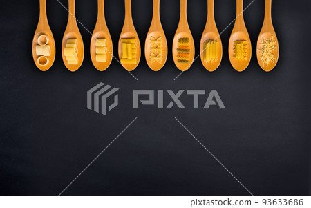 Wooden cooking spoons filled with various types dry pasta Wooden cooking spoons filled with various types dry pasta 93633686